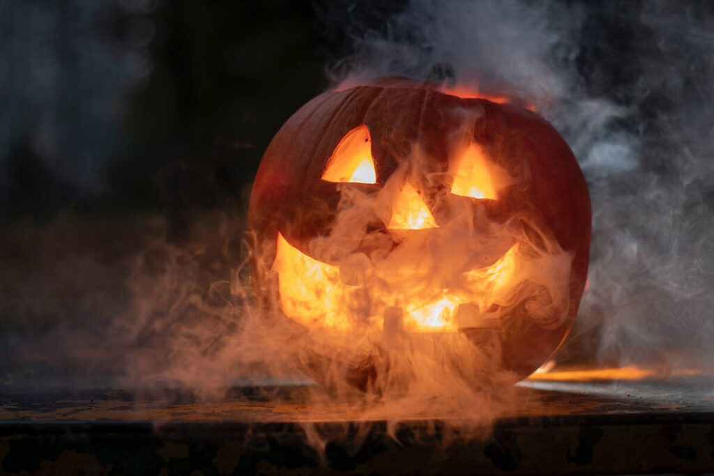 smiling jack-o-lantern pumpkin with smoke surrounding